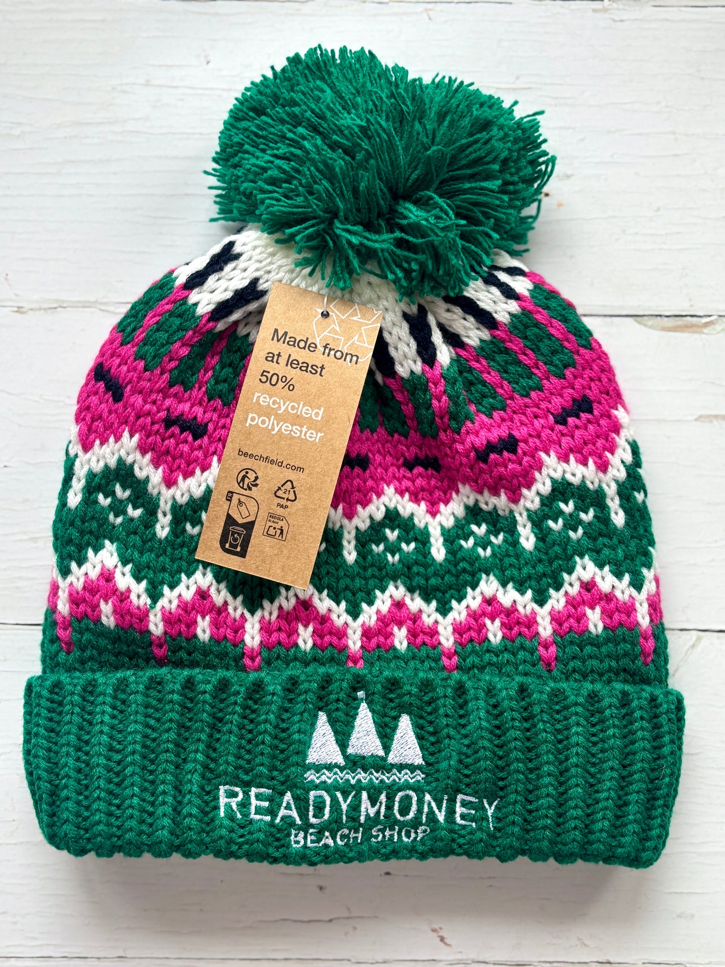 retro bobble hat with green ribbed brim, pink-white zigzag knit, and sailboat logo—eye-catching, recycled winter accessory