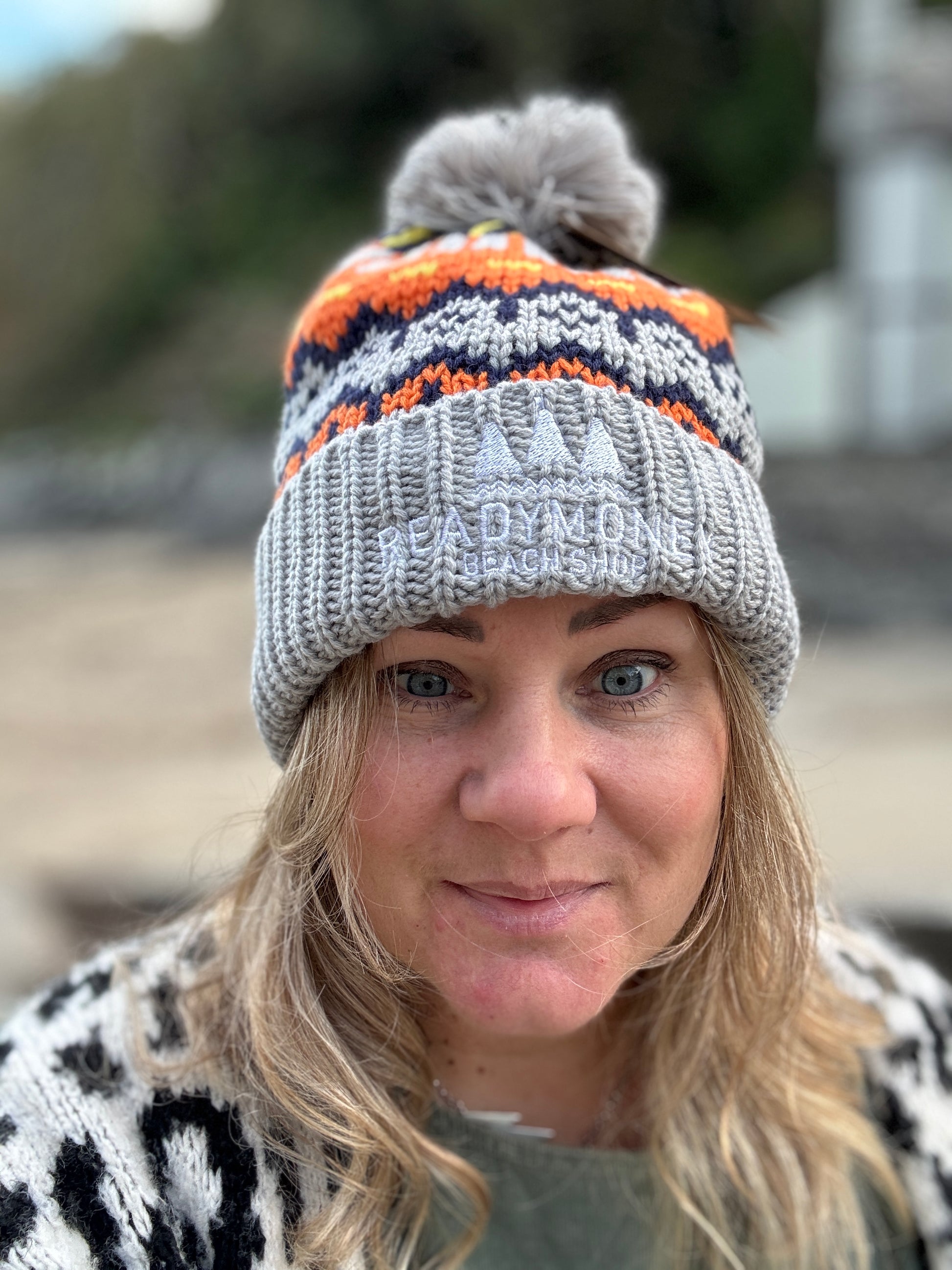 colorful retro knit bobble hat with soft gray ribbed brim and beachside embroidery—vibrant winterwear for seaside adventures