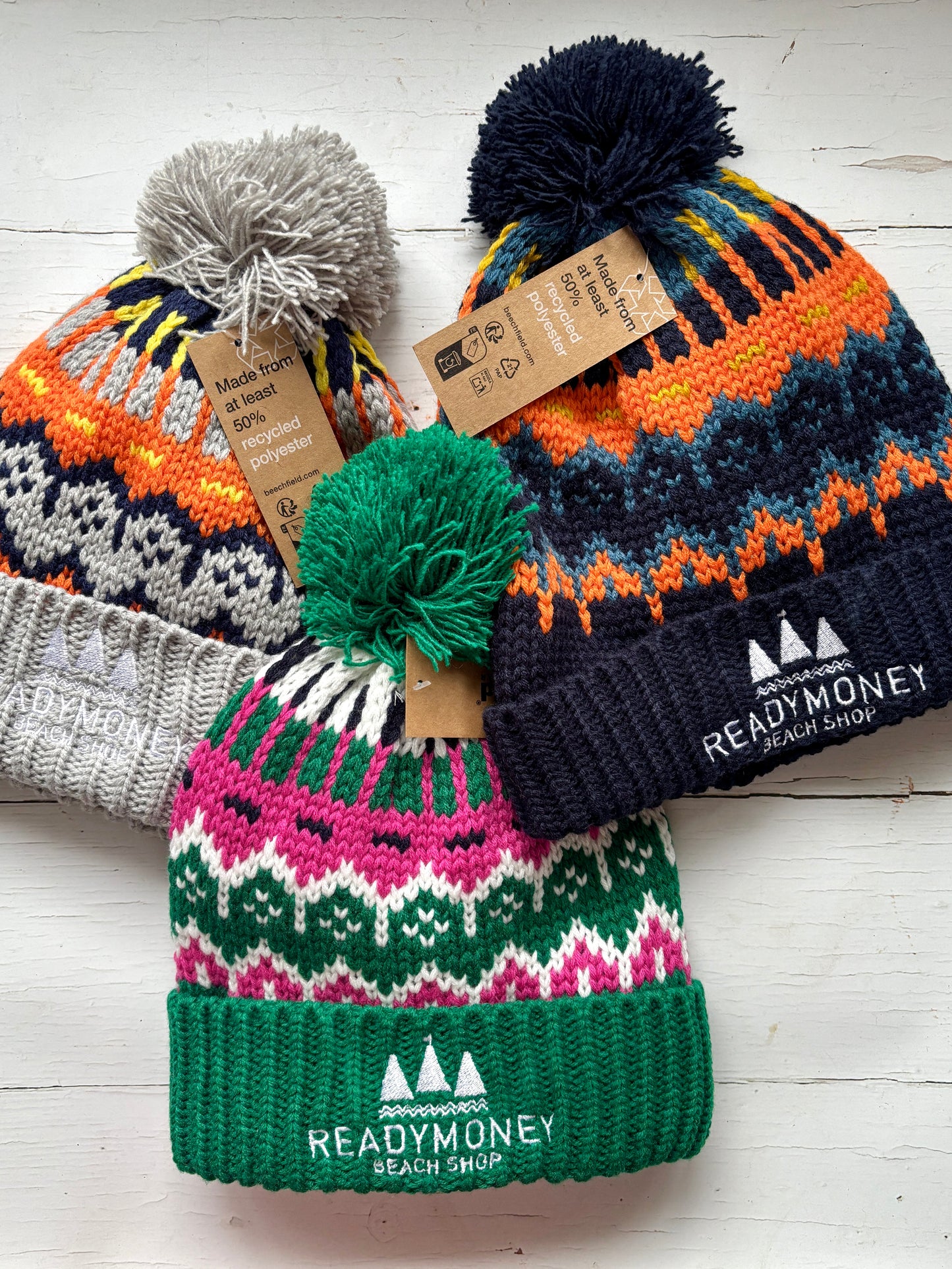 set of retro knit bobble hats with bold zigzag patterns, ribbed brims, and eco tags—colorful, recycled winter accessories