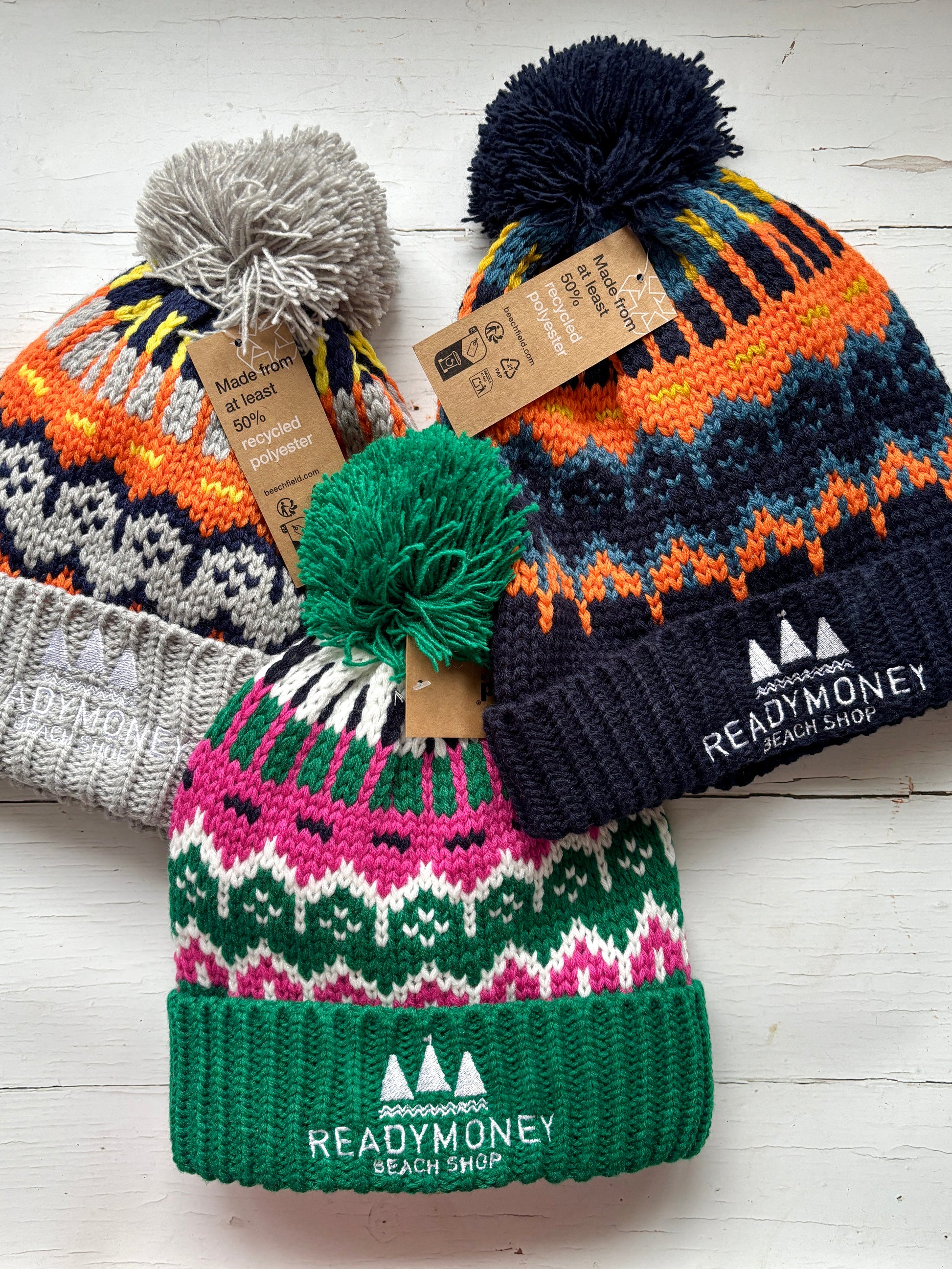 set of retro knit bobble hats with bold zigzag patterns, ribbed brims, and eco tags—colorful, recycled winter accessories