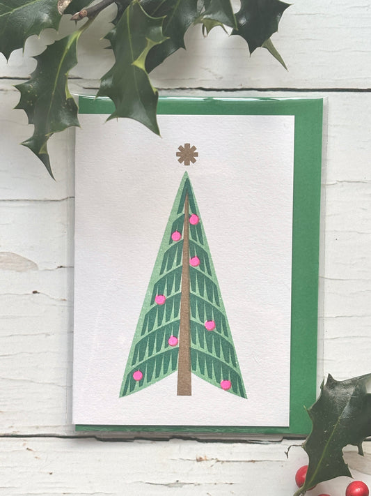 retro style Christmas card with minimalist green tree, pink baubles, and gold star, festive modern holiday design