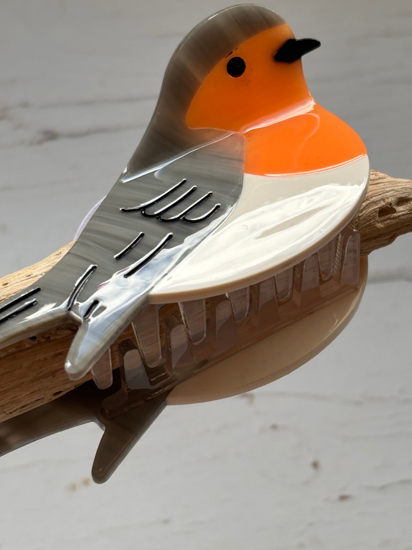 closeup shot of robin bird hair claw – glossy clip with etched wings, orange chest, and secure grip for nature-inspired styling