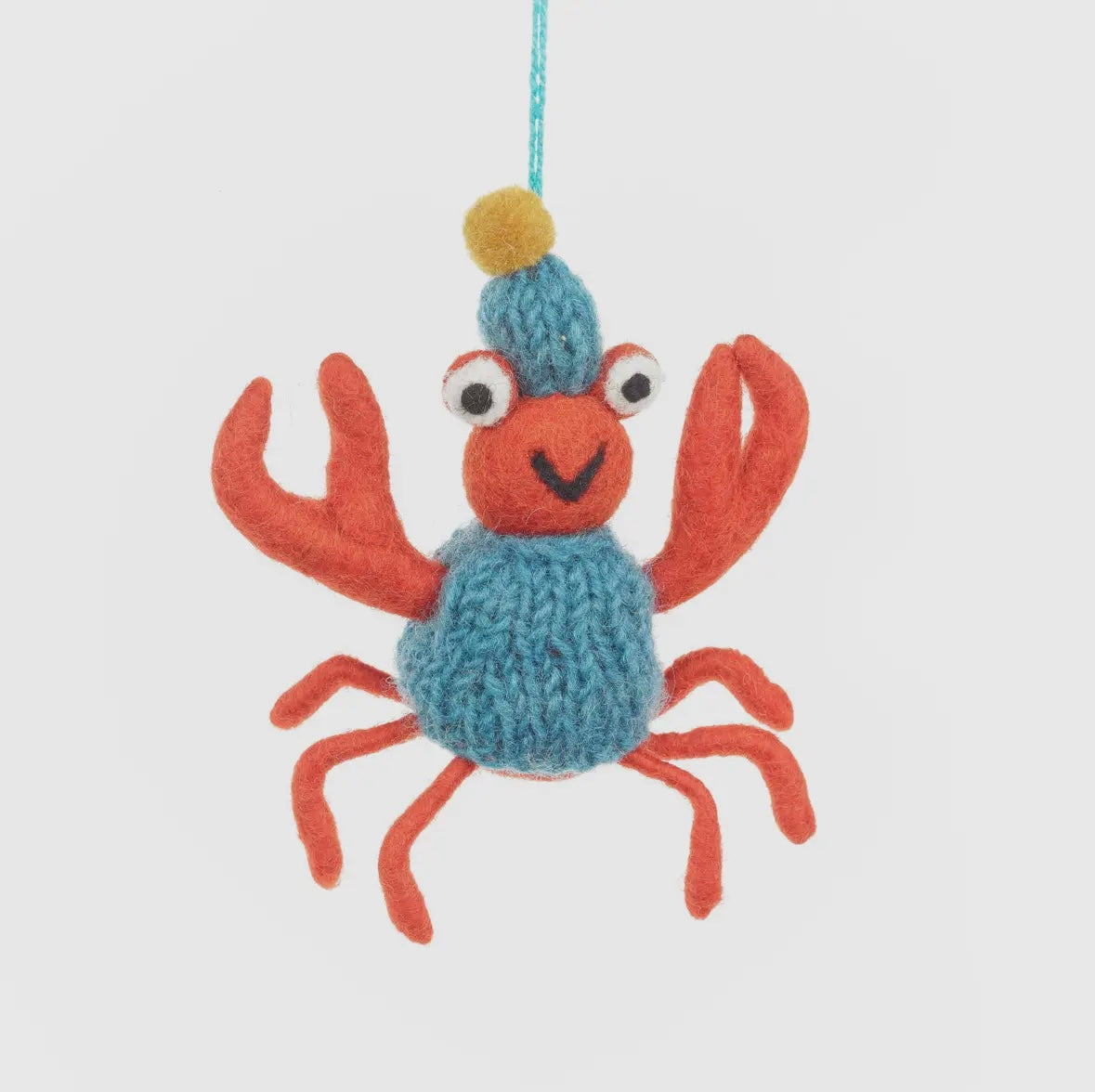 closeup shot of hand-felted red crab ornament with knit hat, coastal holiday decor for beach-themed styling