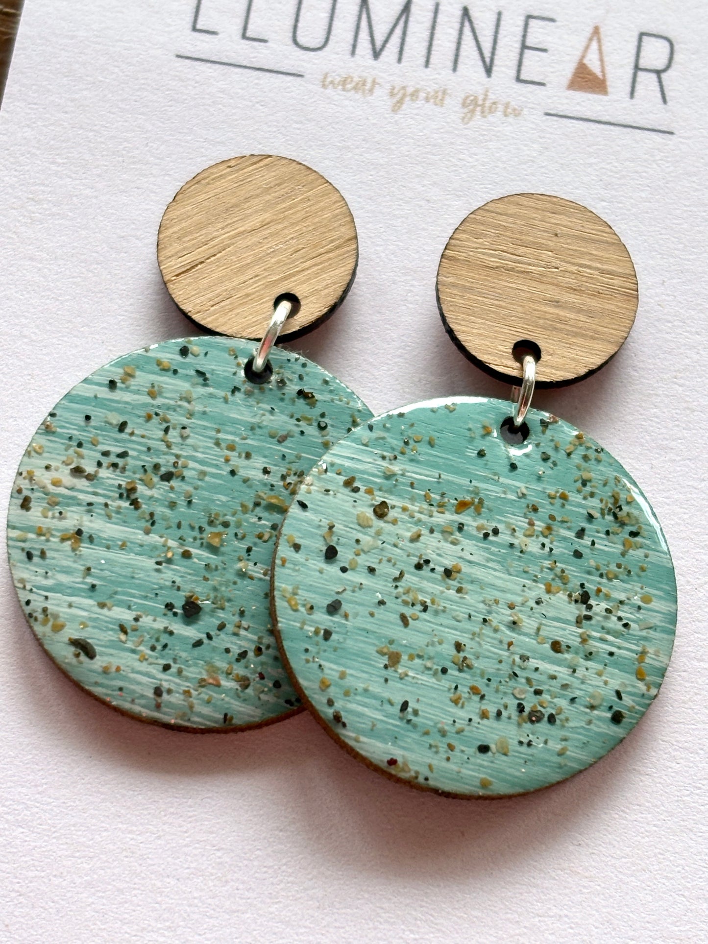 mint sterling silver stud earrings closeup wood top with genuine sand-speckled resin coastal-inspired dangle jewelry