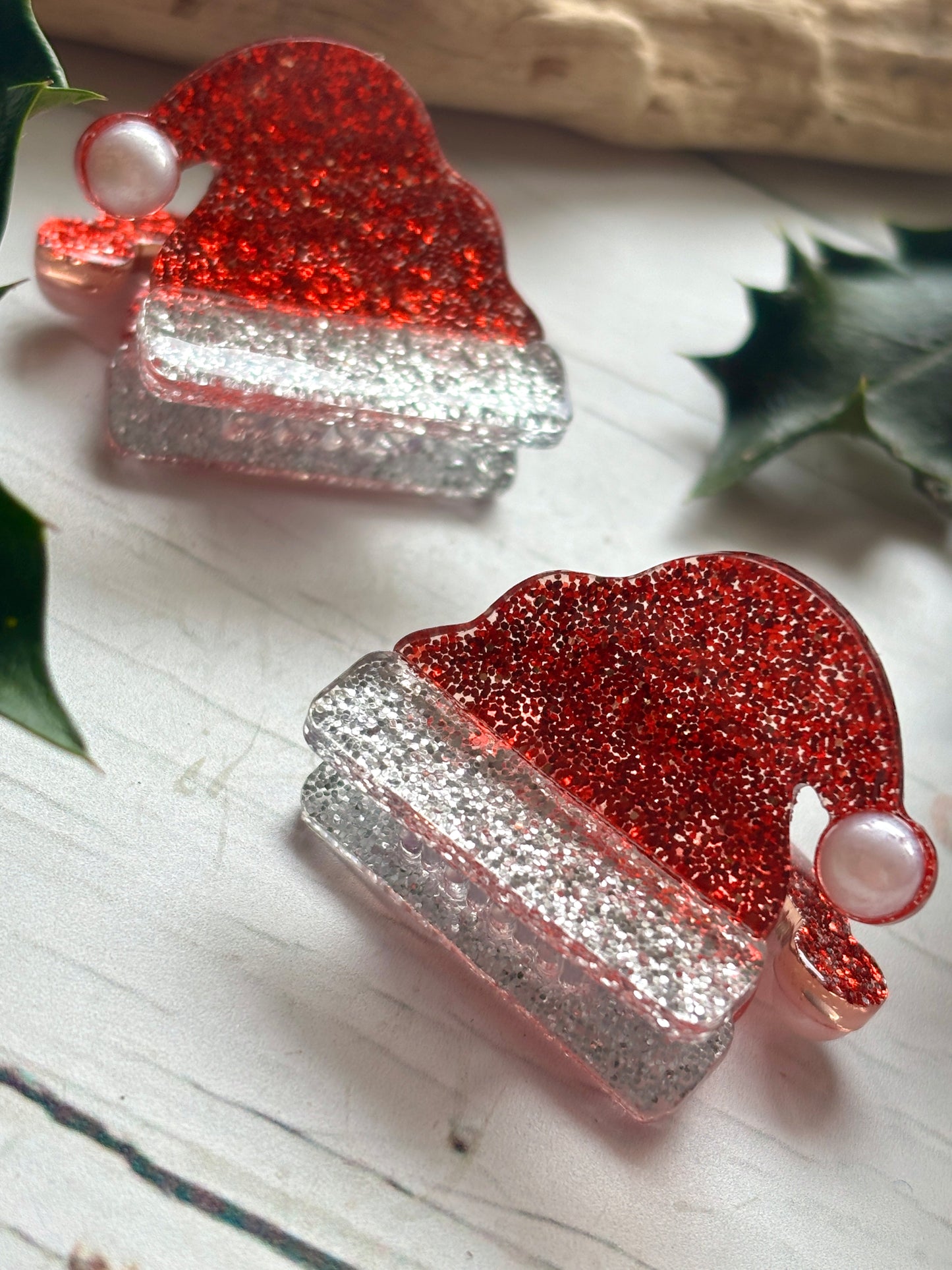 closeup shot of on red glitter Santa hat hair clip silver sparkle trim and pearl bead pompom mini festive hair accessories