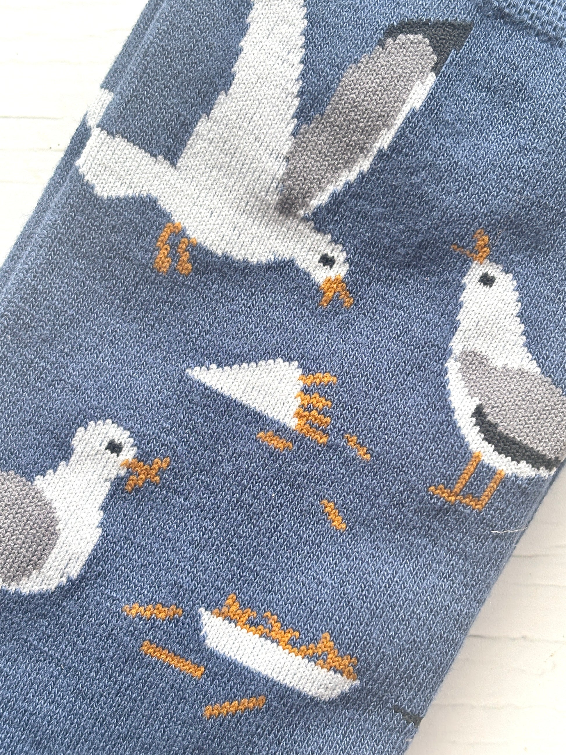closeup shot of seagull bamboo socks—fun fries and bird pattern on soft blue knit, perfect for seaside gifting and eco-friendly sock lovers