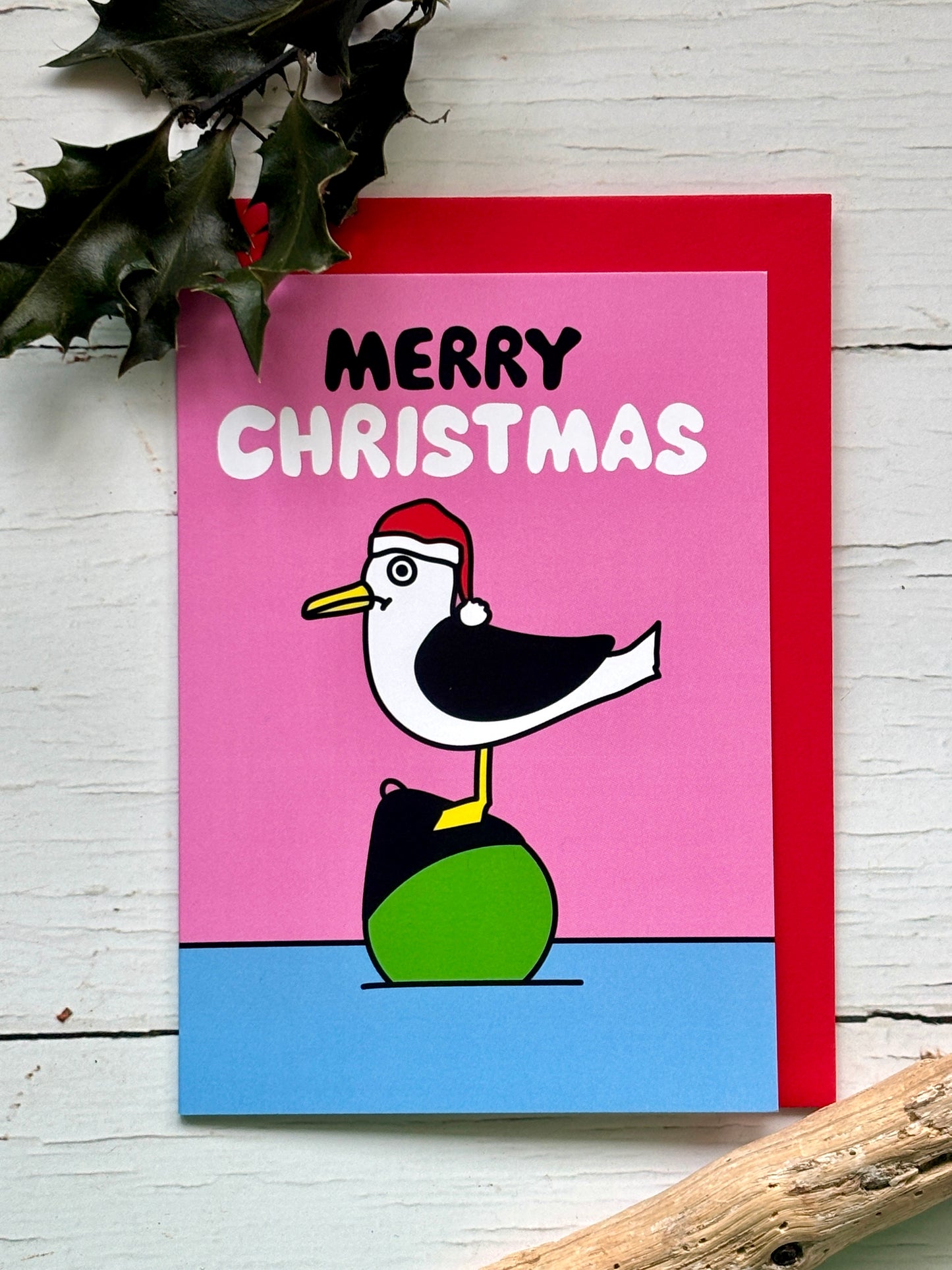 Cute seagull Christmas card with Santa hat and “Merry Christmas” text on pink background, fun festive holiday greeting design