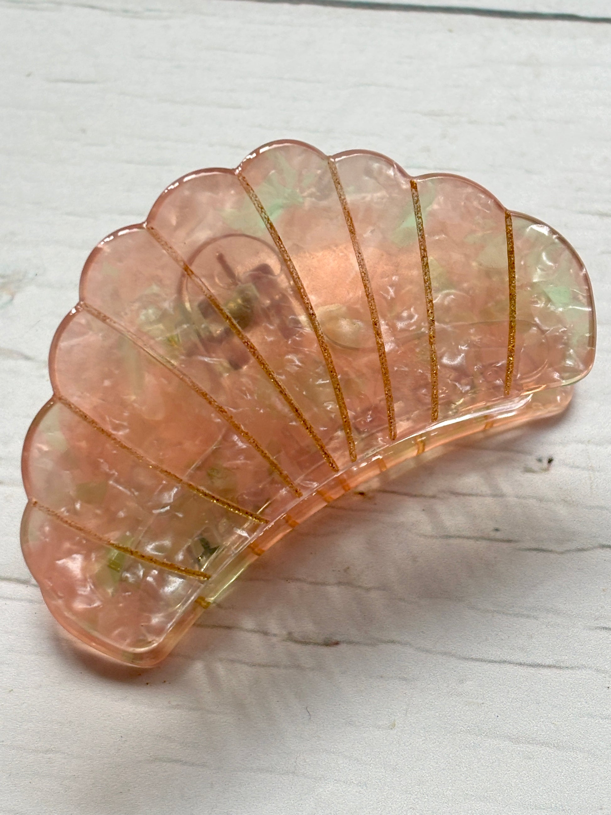 glamorous seashell hair claw clip with an iridescent pink/gold marbled finish and sparkling gold glitter detail mermaid hair accessory