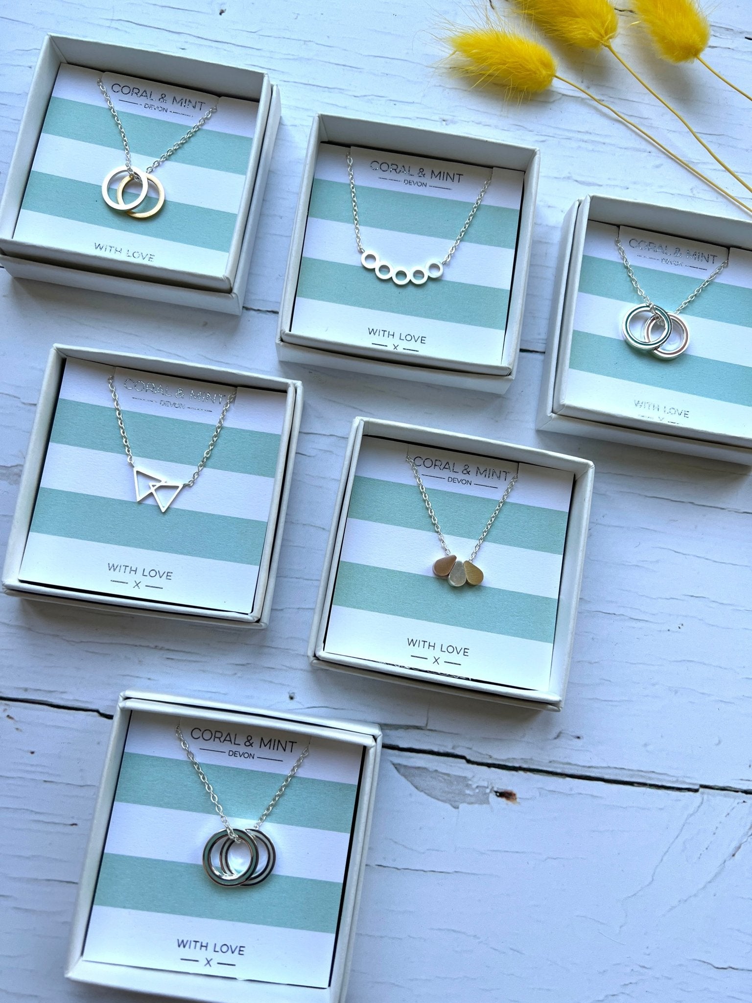 minimalist geometric pendant necklaces by Coral & Mint on striped gift cards elegant silver & gold jewelry