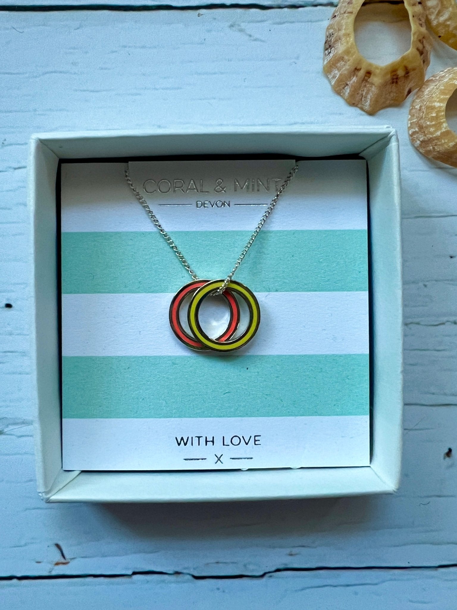 coral and yellow enamel double ring necklace by Coral & Mint silver minimalist jewelry on a striped gift card chic gift