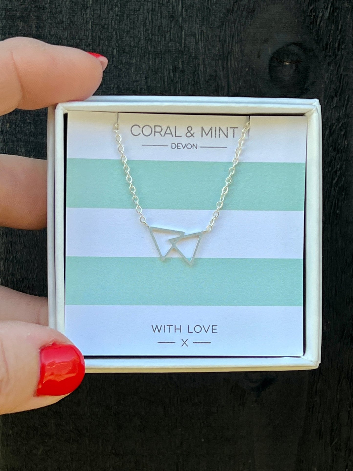 silver double triangle necklace by Coral & Mint minimalist geometric jewelry on striped gift card chic jewelry gift