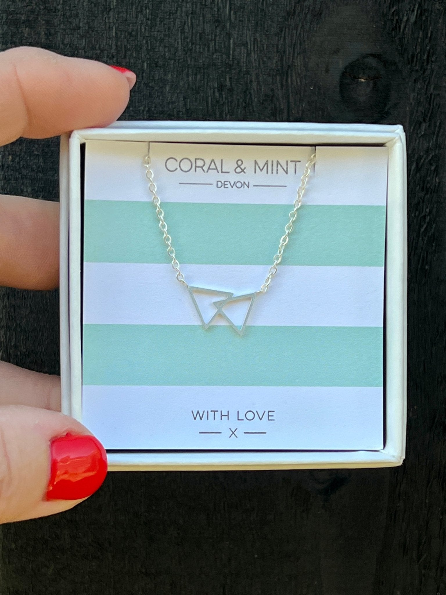 silver double triangle necklace by Coral & Mint minimalist geometric jewelry on striped gift card chic jewelry gift