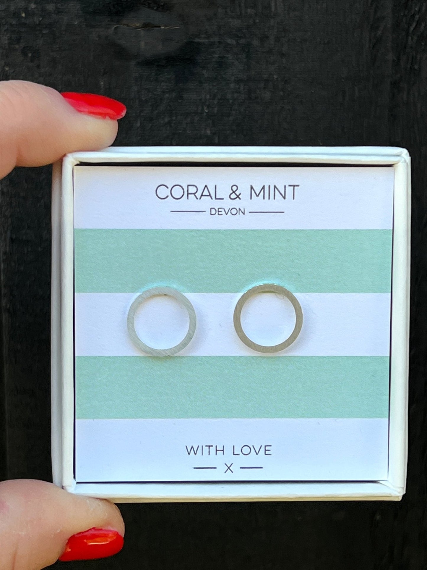 silver open circle stud earrings by Coral & Mint minimalist geometric jewelry on a striped gift card chic gift idea