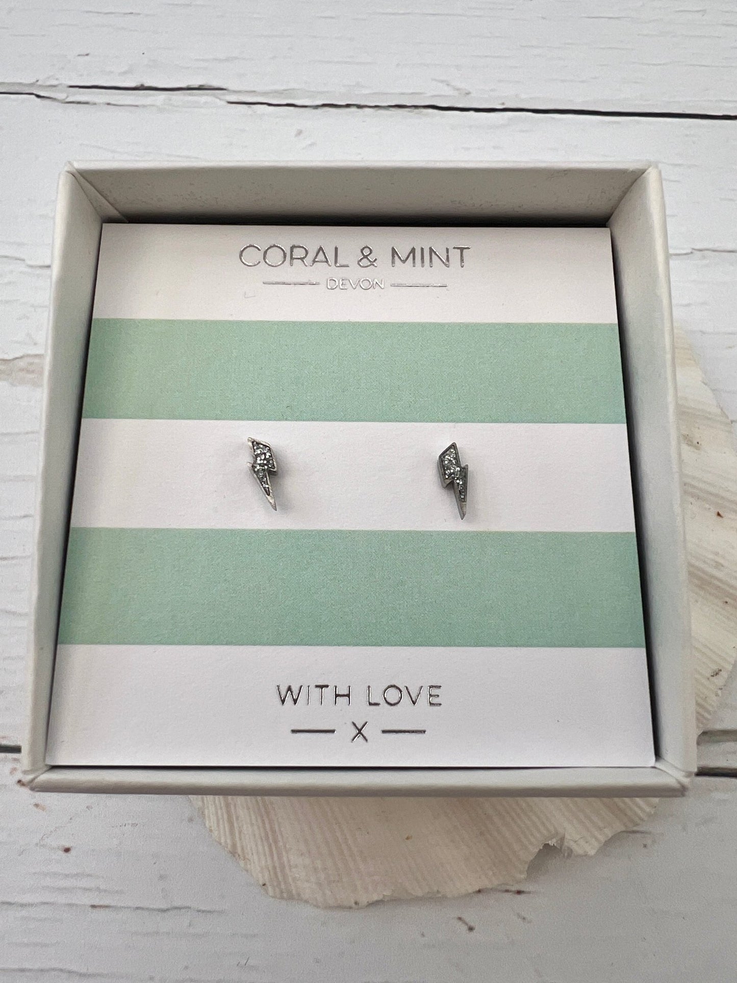 silver lightning bolt stud earrings by Coral & Mint dainty celestial jewelry on a striped gift card edgy gift idea