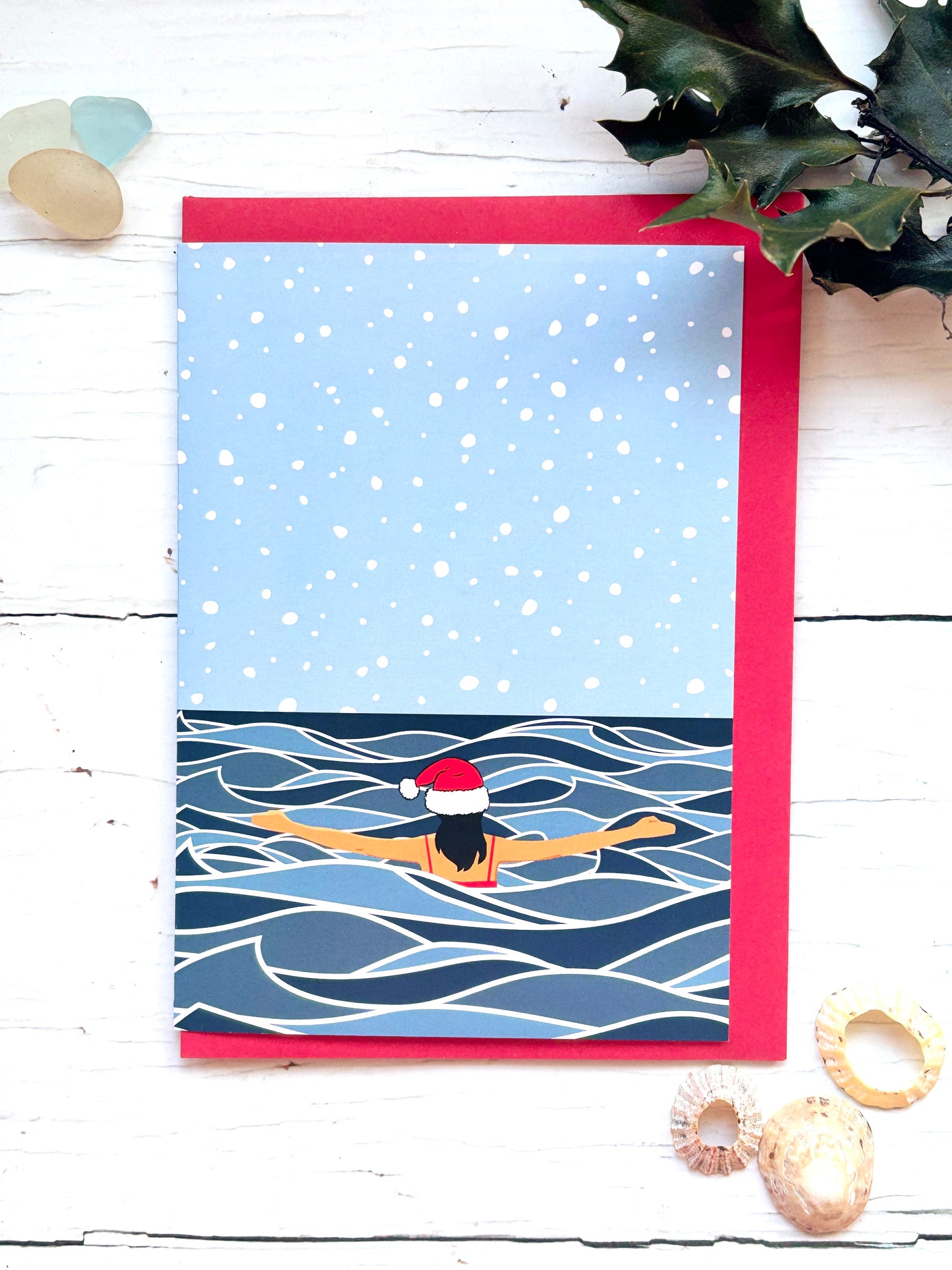 solo Christmas swim card showing winter sea swimmer in Santa hat, snowy ocean scene, festive cold water swimming