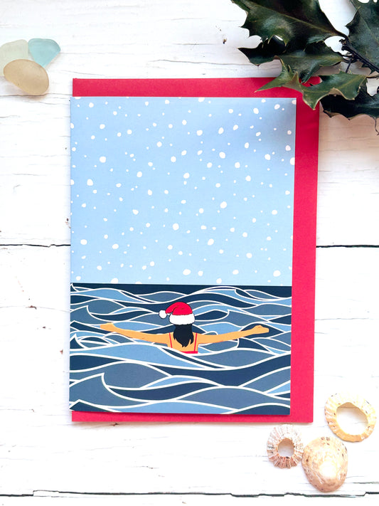 solo Christmas swim card showing winter sea swimmer in Santa hat, snowy ocean scene, festive cold water swimming