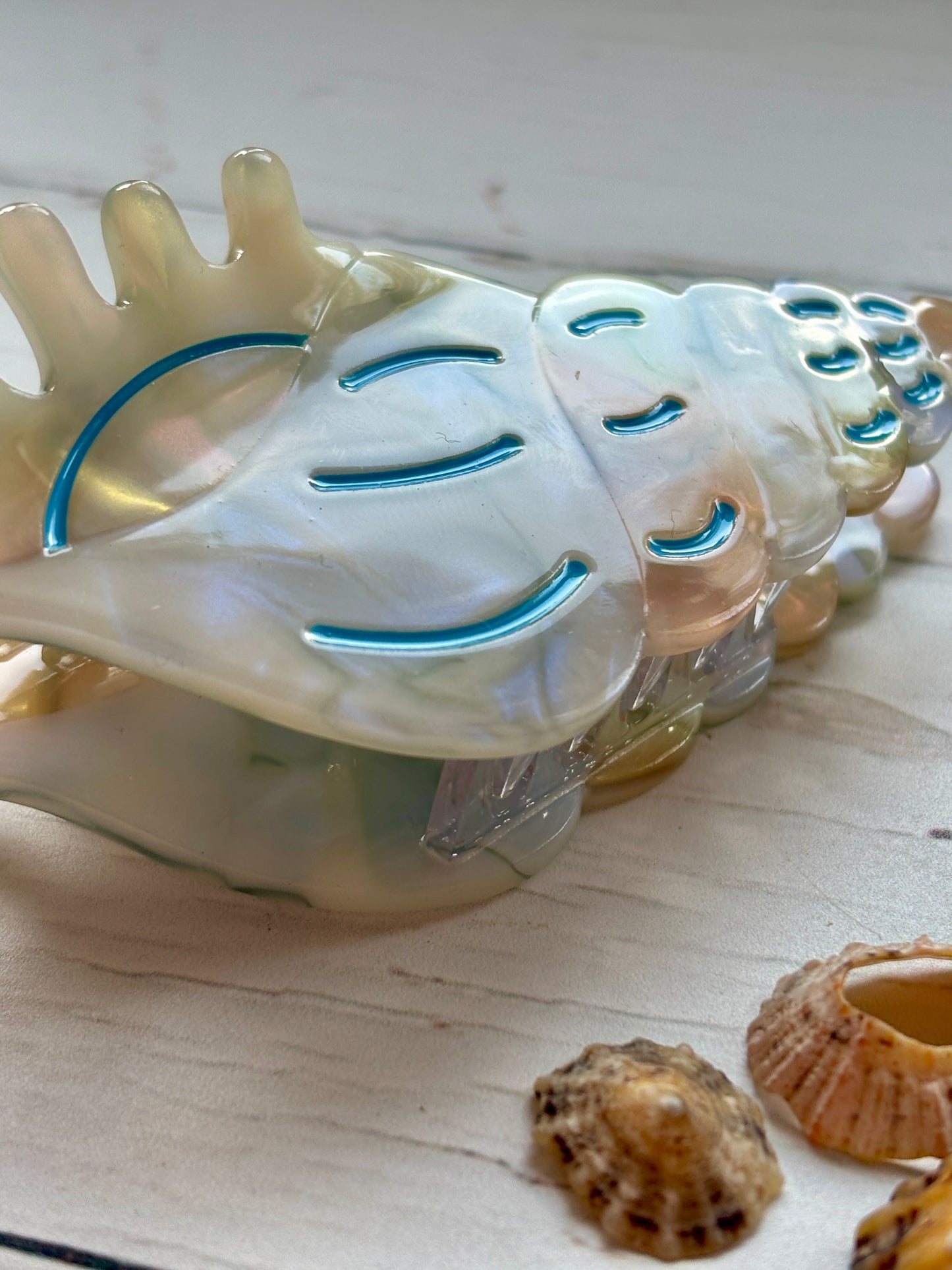 pearlescent spiral shell hair claw with blue accents—elegant beach-inspired clip for summer styling