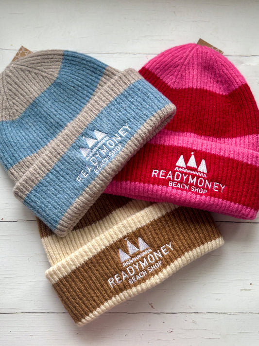 Striped knit beanies with “Readymoney Beach Shop” embroidery—coastal-inspired winter hats in pink, blue, and neutral tones