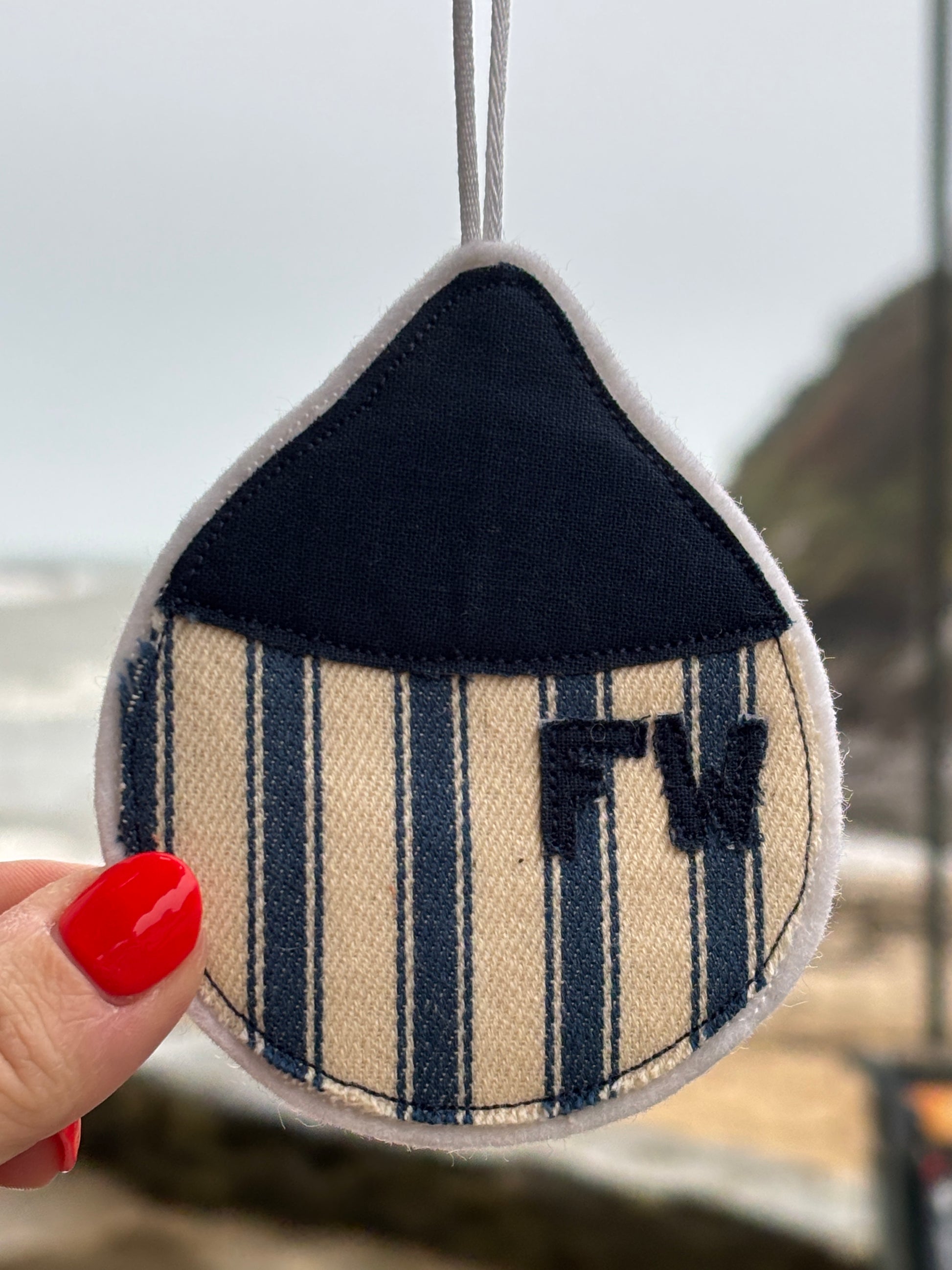 striped buoy-shaped fabric hanging with embroidered “FW”—handcrafted nautical accent for coastal-inspired decor