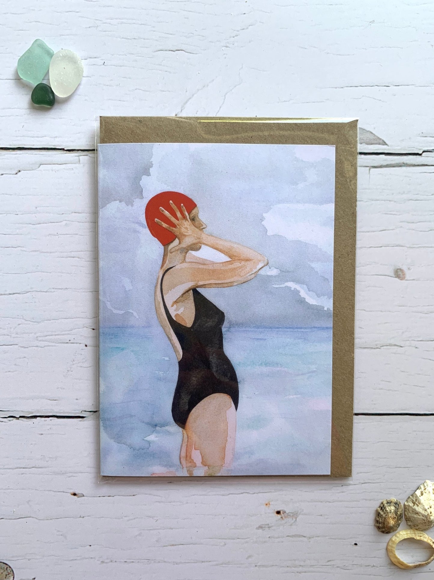 red swim cap wild swimmer card—artful beach scene in soft watercolor tones for coastal-inspired gifting