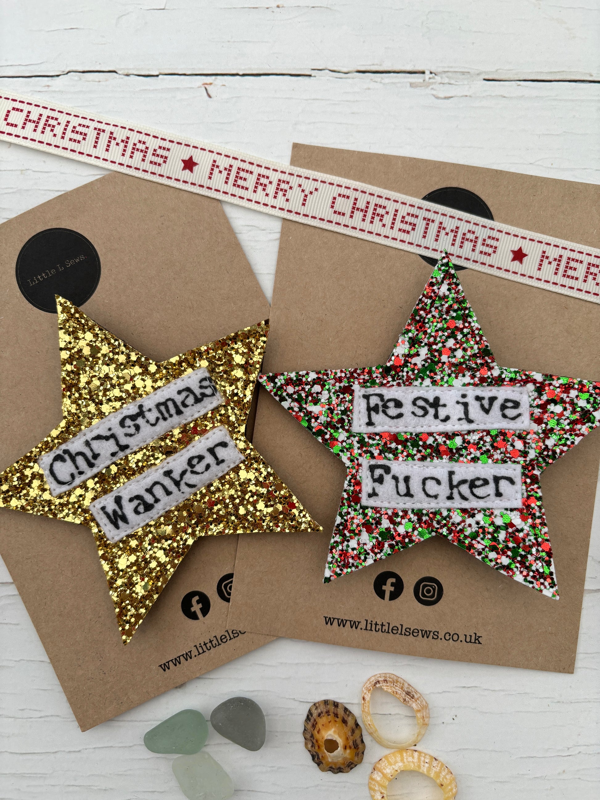 closeup shot of sweary glitter star Christmas badges—bold handmade festive decor with cheeky adult humor