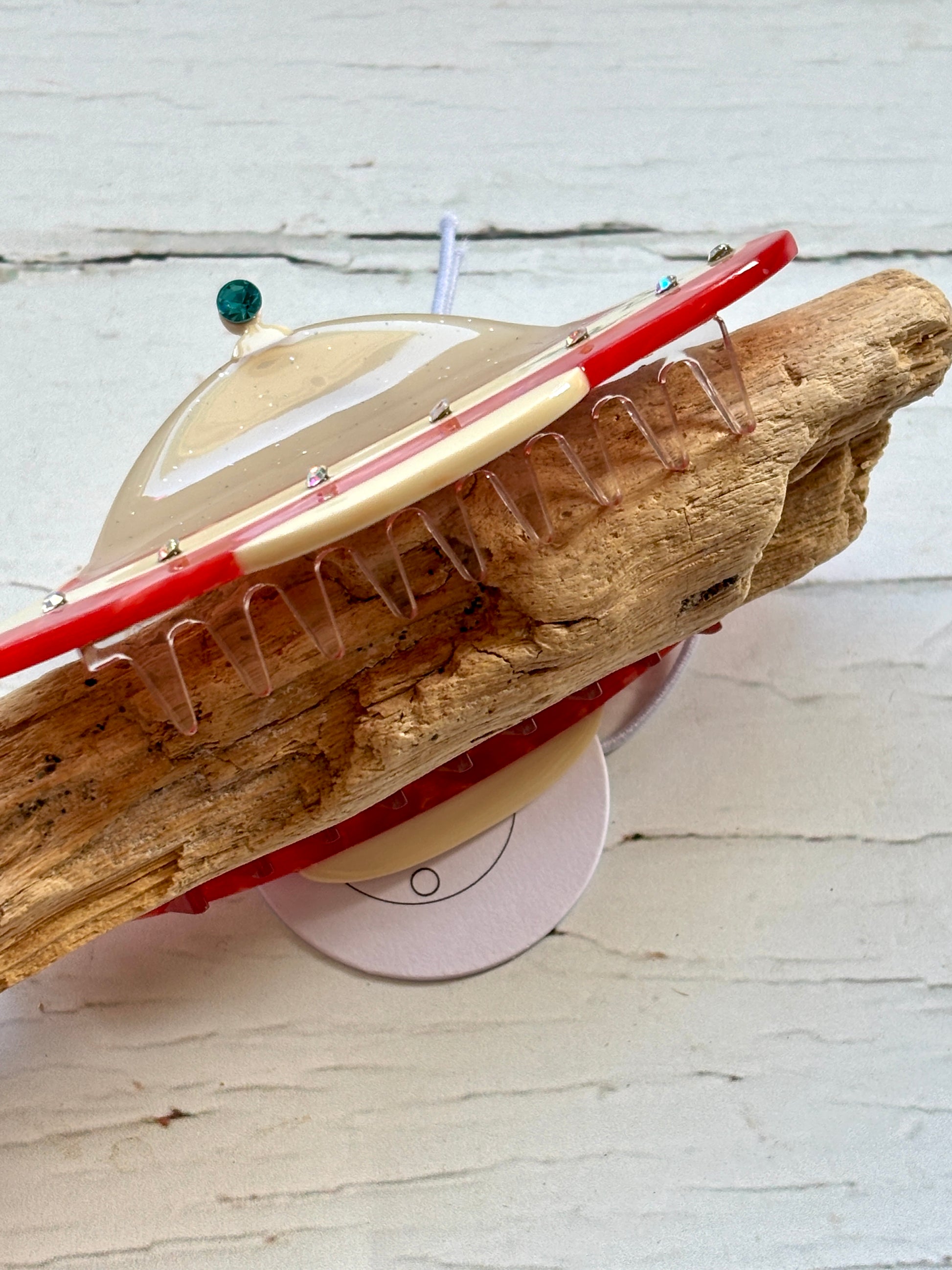 closeup shot of UFO spaceship hair claw—glossy, rhinestone-studded clip with cosmic charm and secure sci-fi-inspired grip