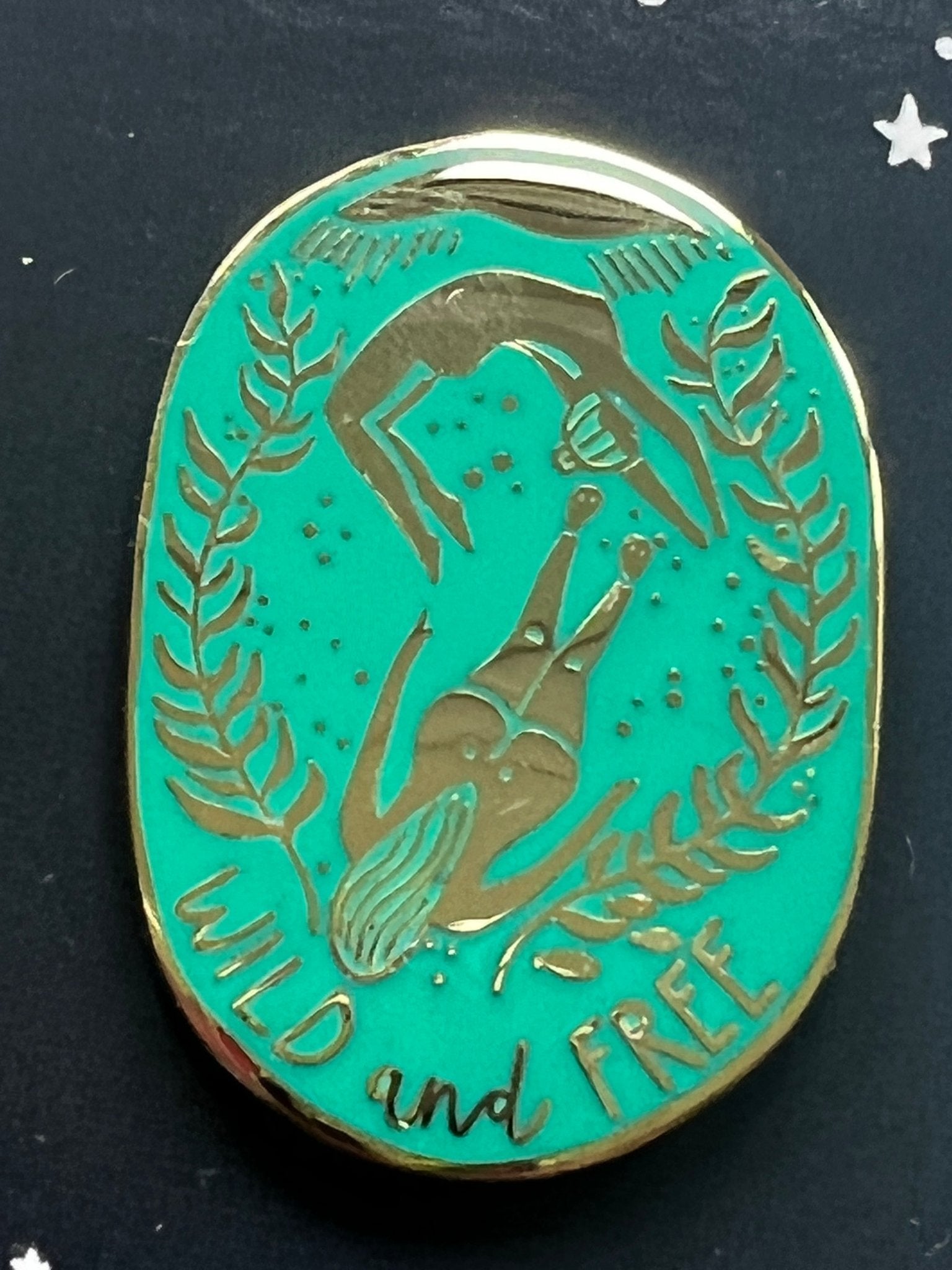 oval enamel pin with gold diver duo, sea plants, and “Wild and Free” quote—nature-inspired underwater accessory