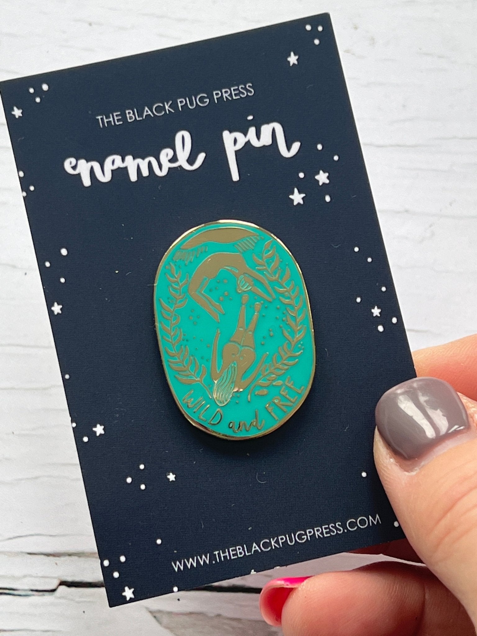 ocean-themed enamel pin featuring diver, sea plants, and “Wild and Free” quote—adventure-inspired accessory