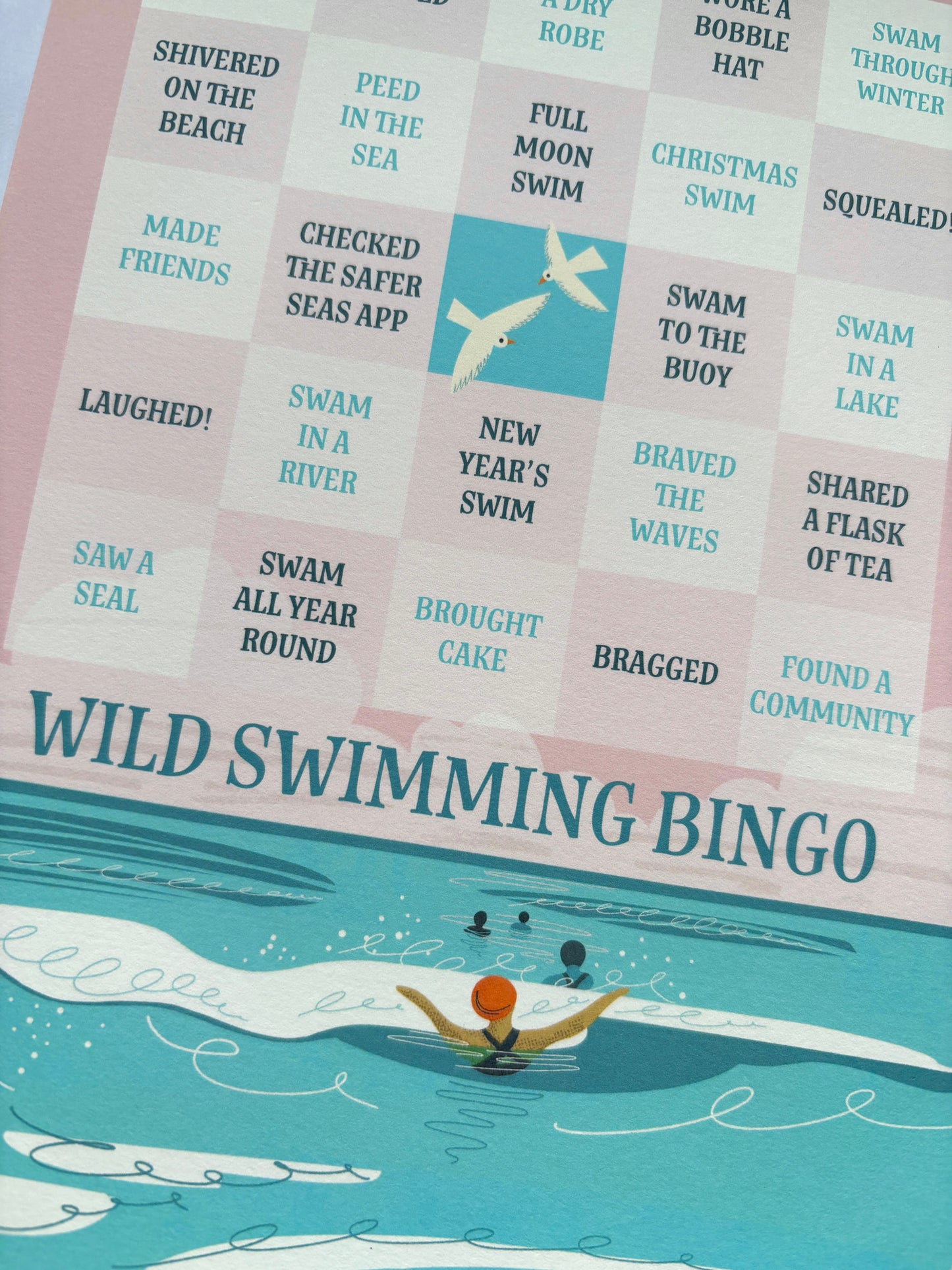 closeup shot of Wild Swimming Bingo card shows text "Found a Community," "Swam All Year Round," and swimmer illustration outdoor activity fun