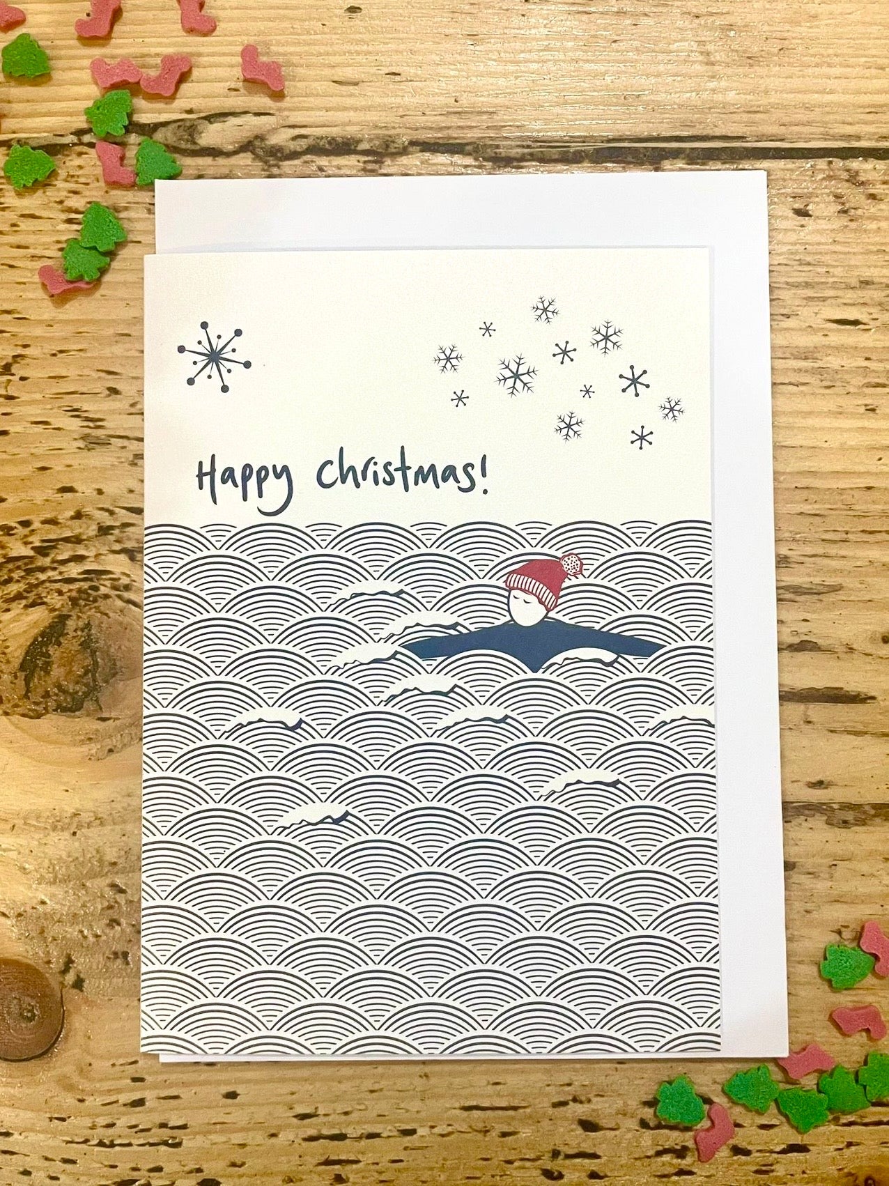Happy Christmas swimmer card, minimalist winter ocean waves design with snowflakes, eco friendly festive holiday greeting card