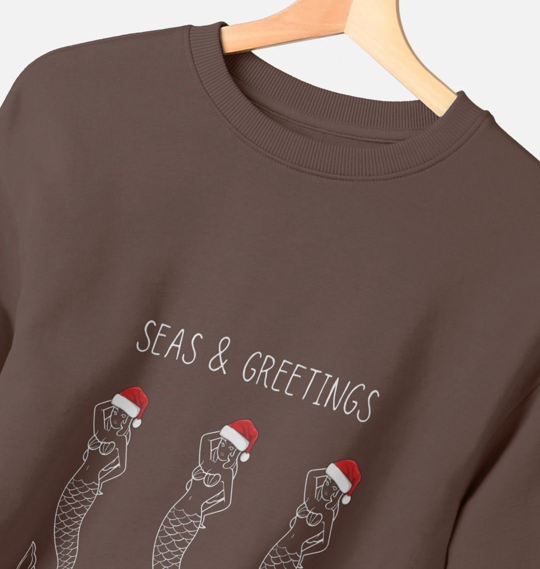 women's chocolate Christmas sweatshirt—three Santa-hat mermaids, “Seas & Greetings” nautical holiday graphic