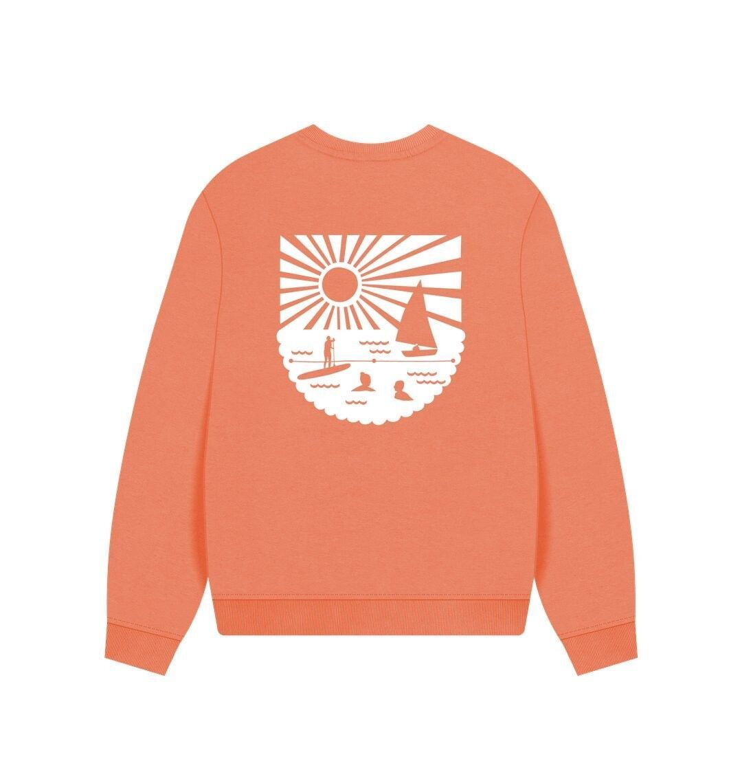 soft apricot oversized women's sweatshirt with bold white coastal graphic—relaxed fit for beach-inspired layering