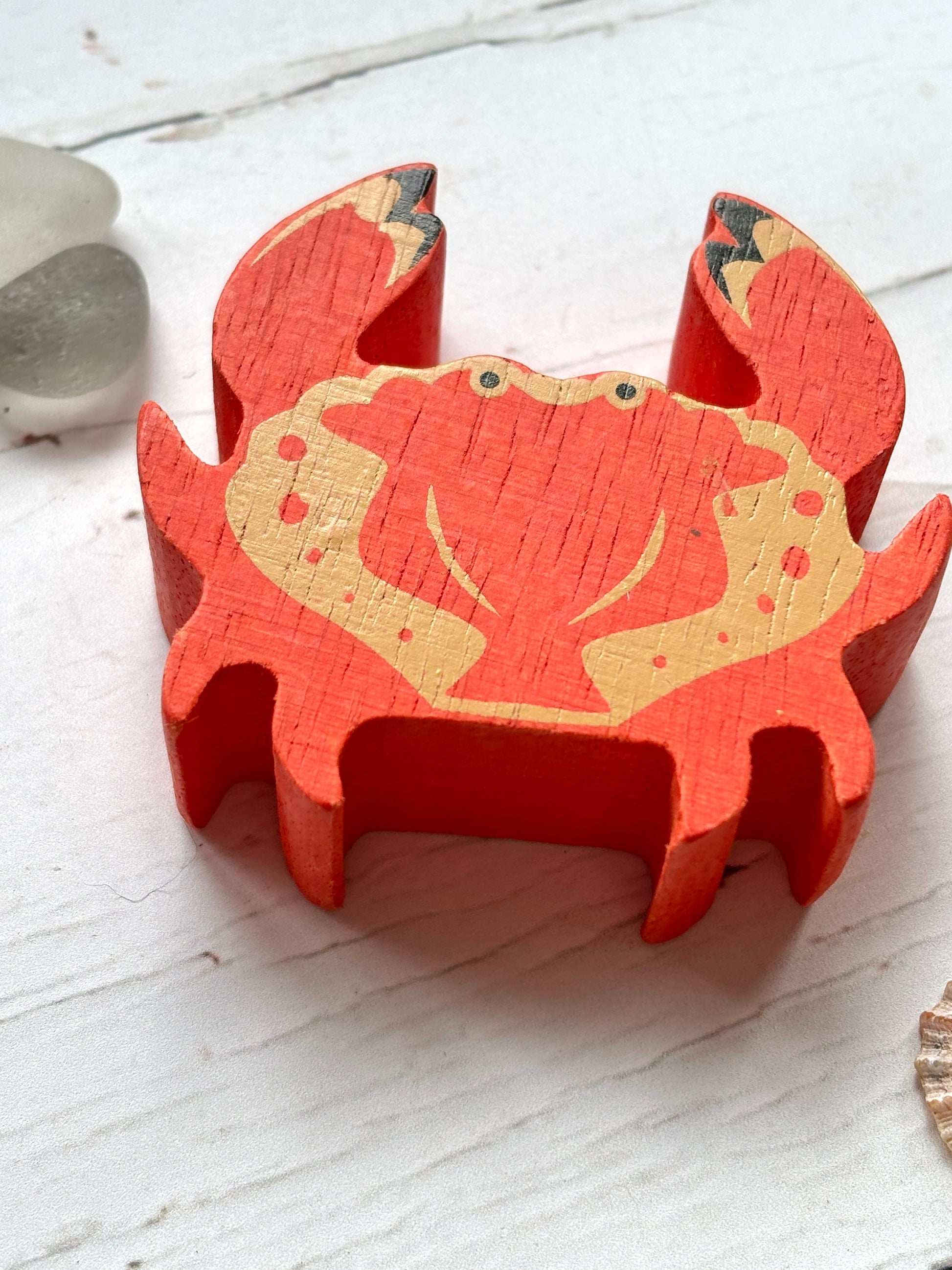 closeup shot of red-orange wooden crab toy with painted claws, beach-themed coastal decor for ocean lovers