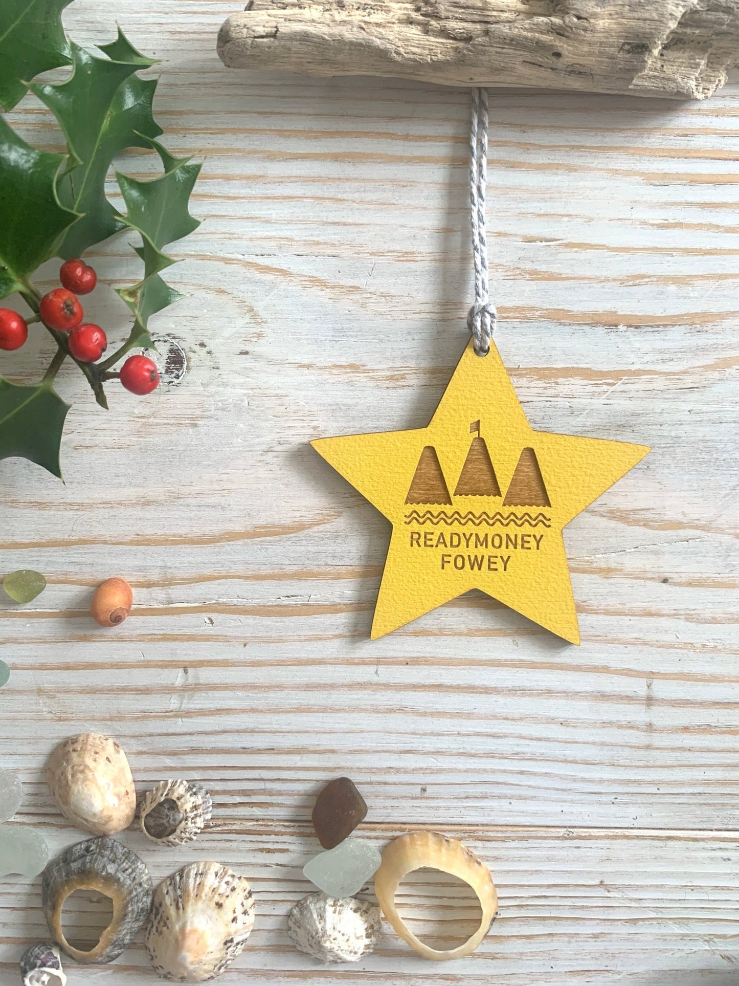 yellow wooden star ornament with “Readymoney Fowey” cut-out design, festive coastal decor with beach charm