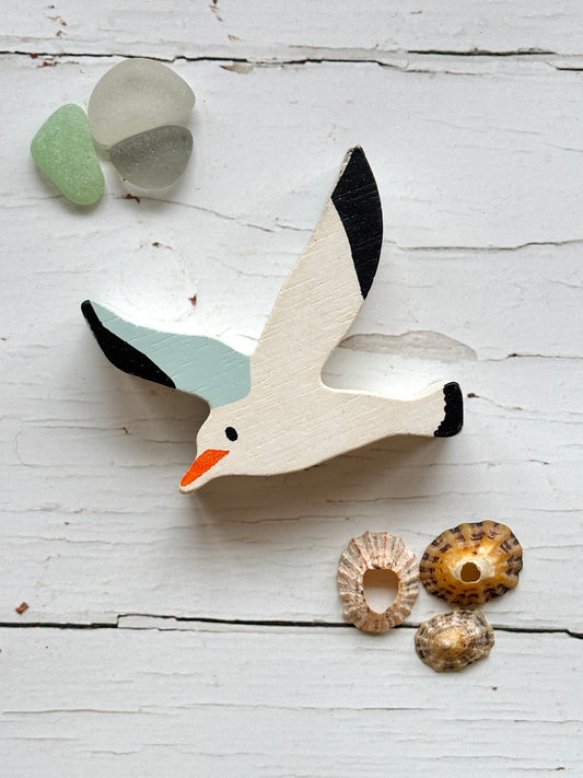 flat wooden seagull toy with painted wings and beak, coastal animal decor for beach-themed play or display