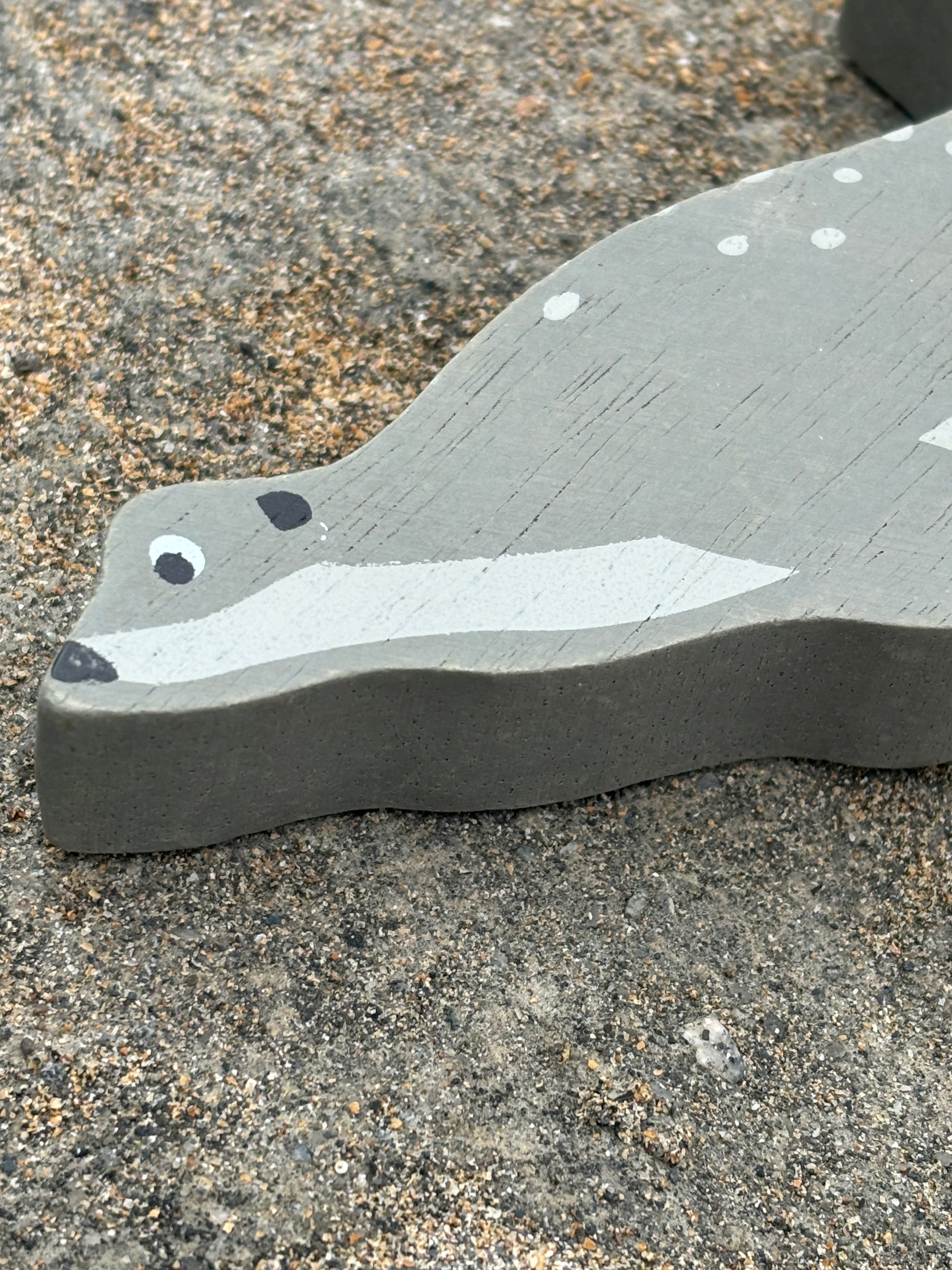 closeup shot of painted wooden seal toy with spotted gray finish, handcrafted coastal decor for beach-themed display