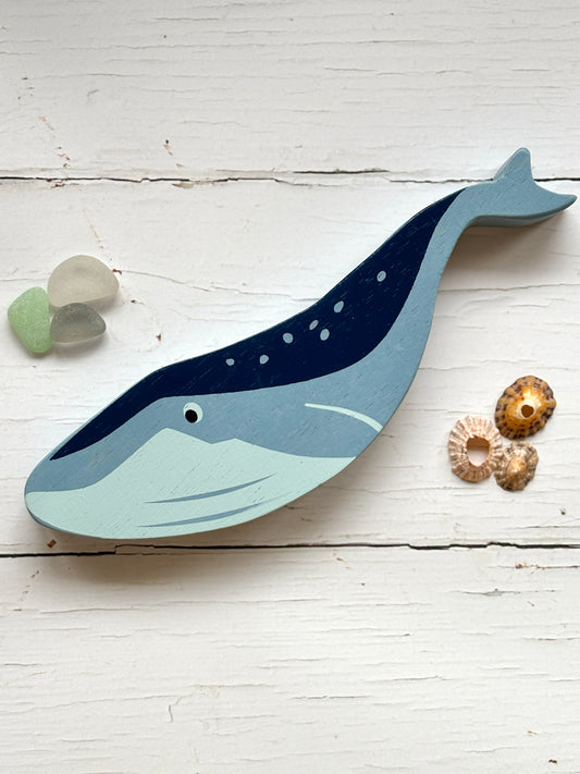 painted wooden whale toy with blue and white spots, handcrafted coastal animal decor for beach-themed play or display