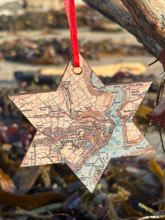 a star shaped wooden christmas decoration with a map pattern