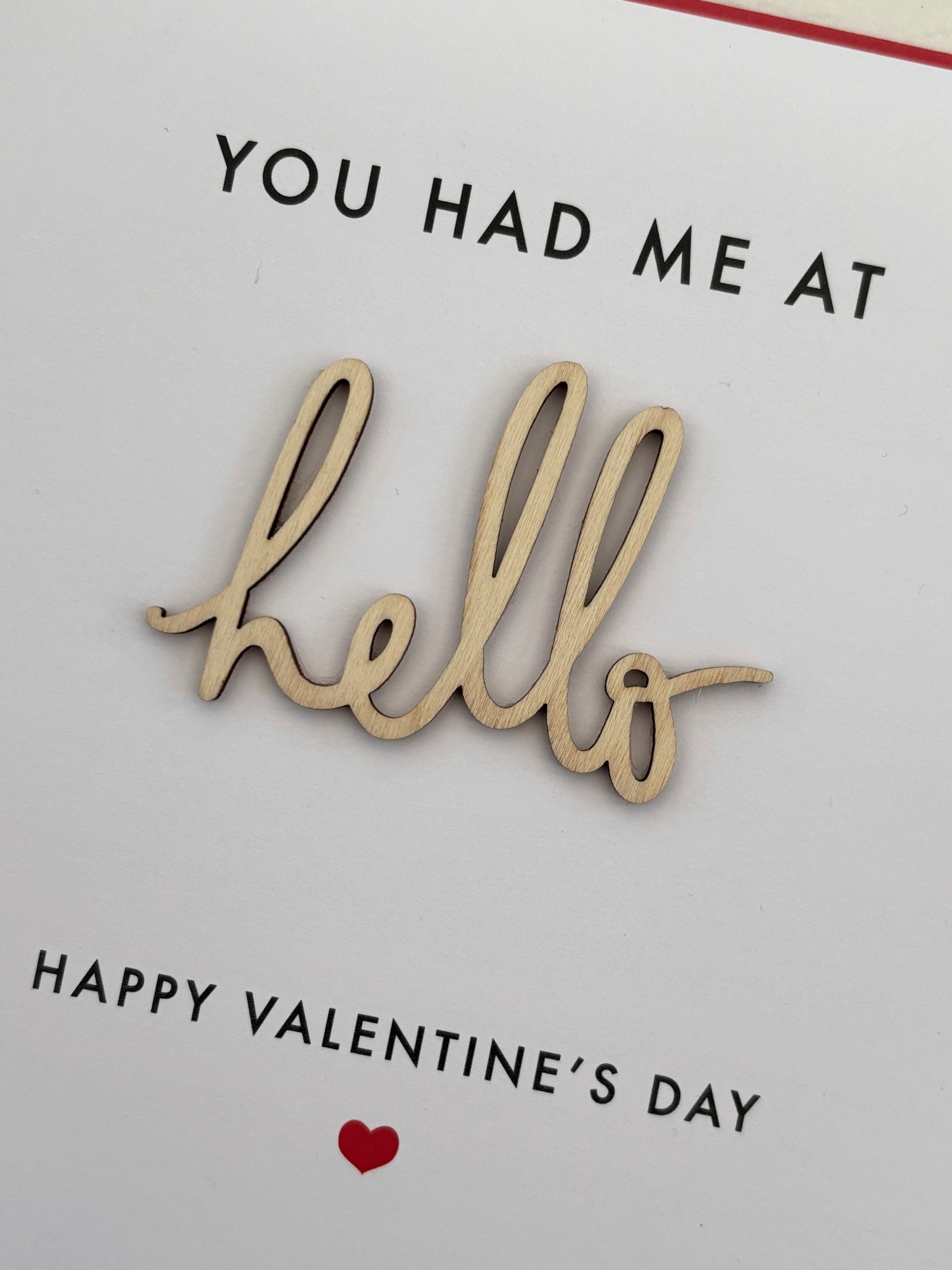 closeup shot of Valentine’s Day card with 3D wooden “hello” cutout, romantic minimalist design for heartfelt gifting