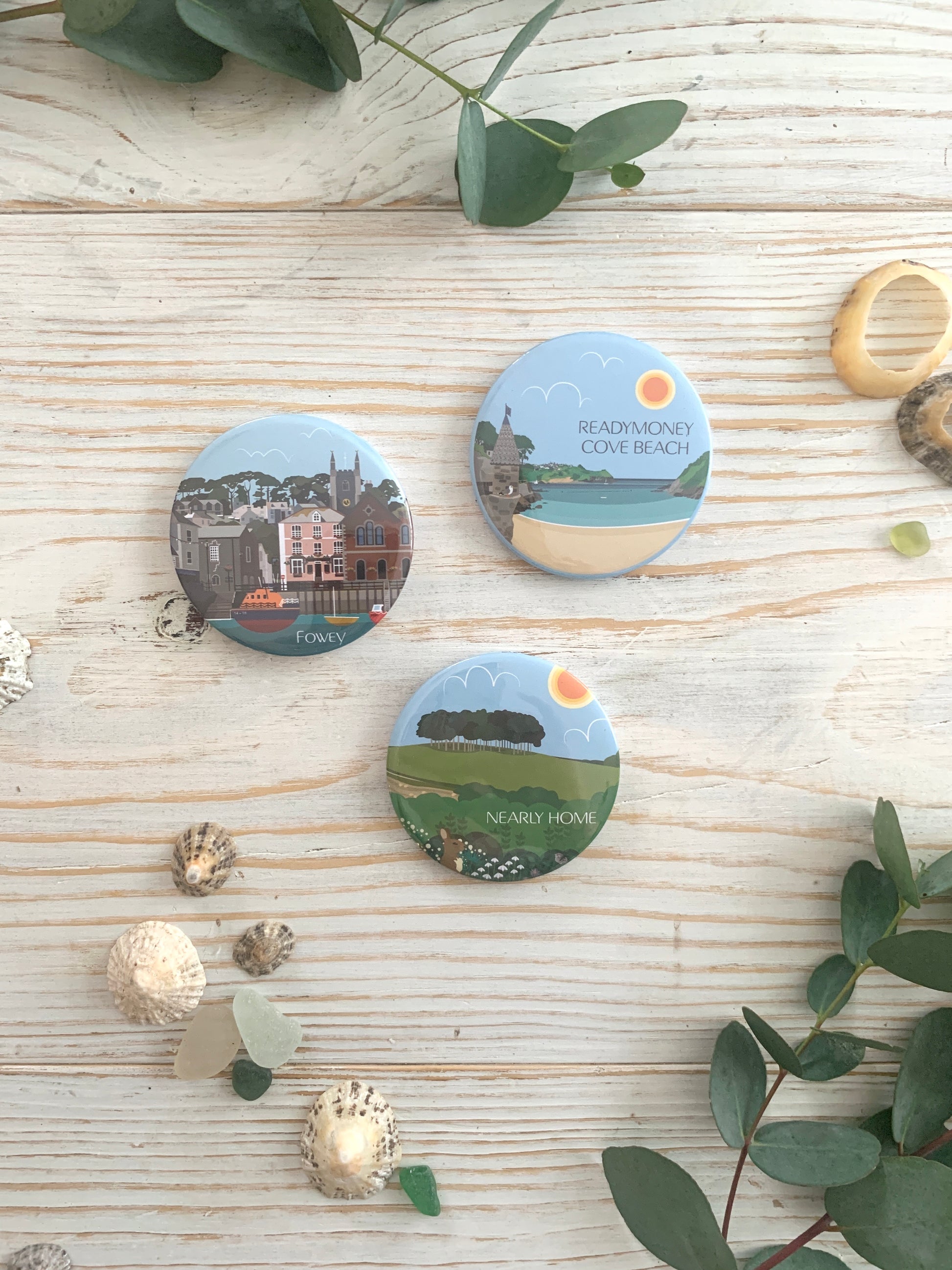 Three colourful fridge magnets depicting Readymoney Cove, Fowey's Town Quay and the Nearly Home Trees