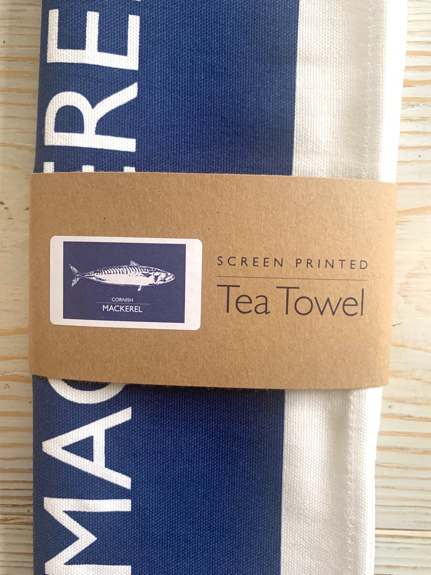 A navy blue tea towel with a mackerel design